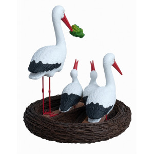 Storkfamilj i bo – dekorativ glasfiberskulptur